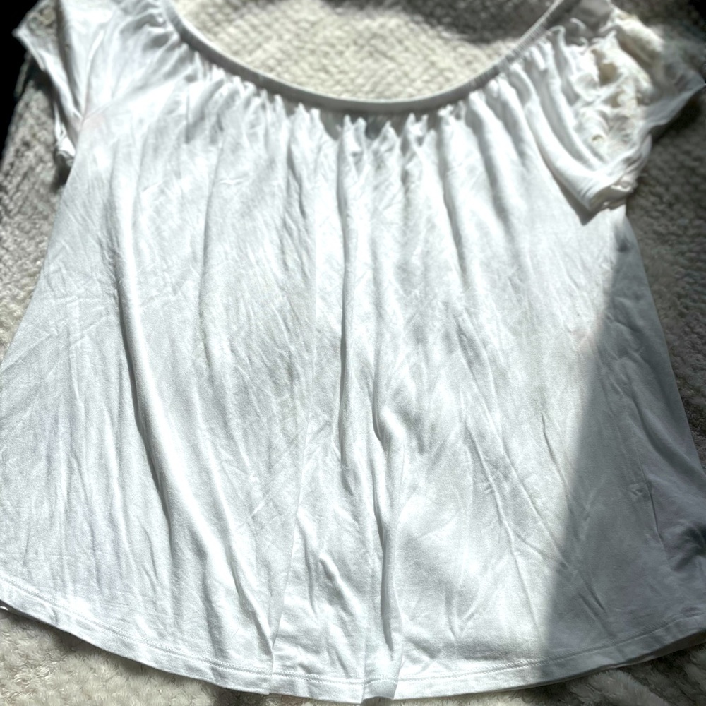 White blouse with flowers on the sleeve.